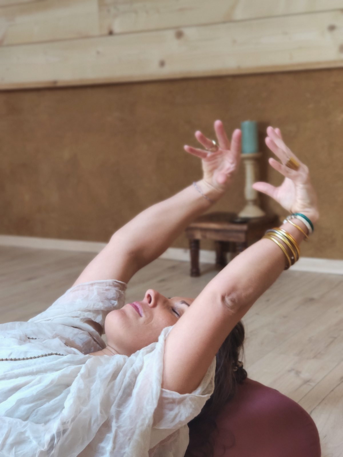 Angélique allongée, bras levés en mudra, lors d'une pratique de souffle