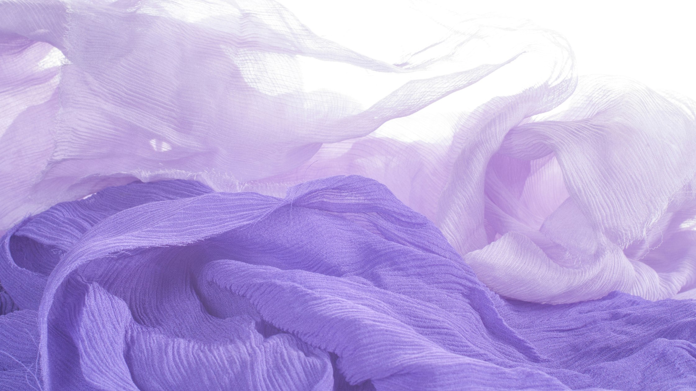 Voiles de tissu mauve et lilas superposés dans la lumière