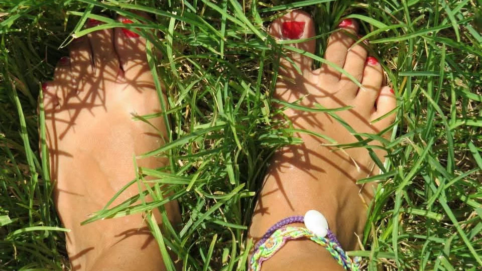 Pieds nus dans l'herbe au soleil, une cheville ornée d'un bracelet tressé&nbsp;: se sentir en sécurité dans son corps